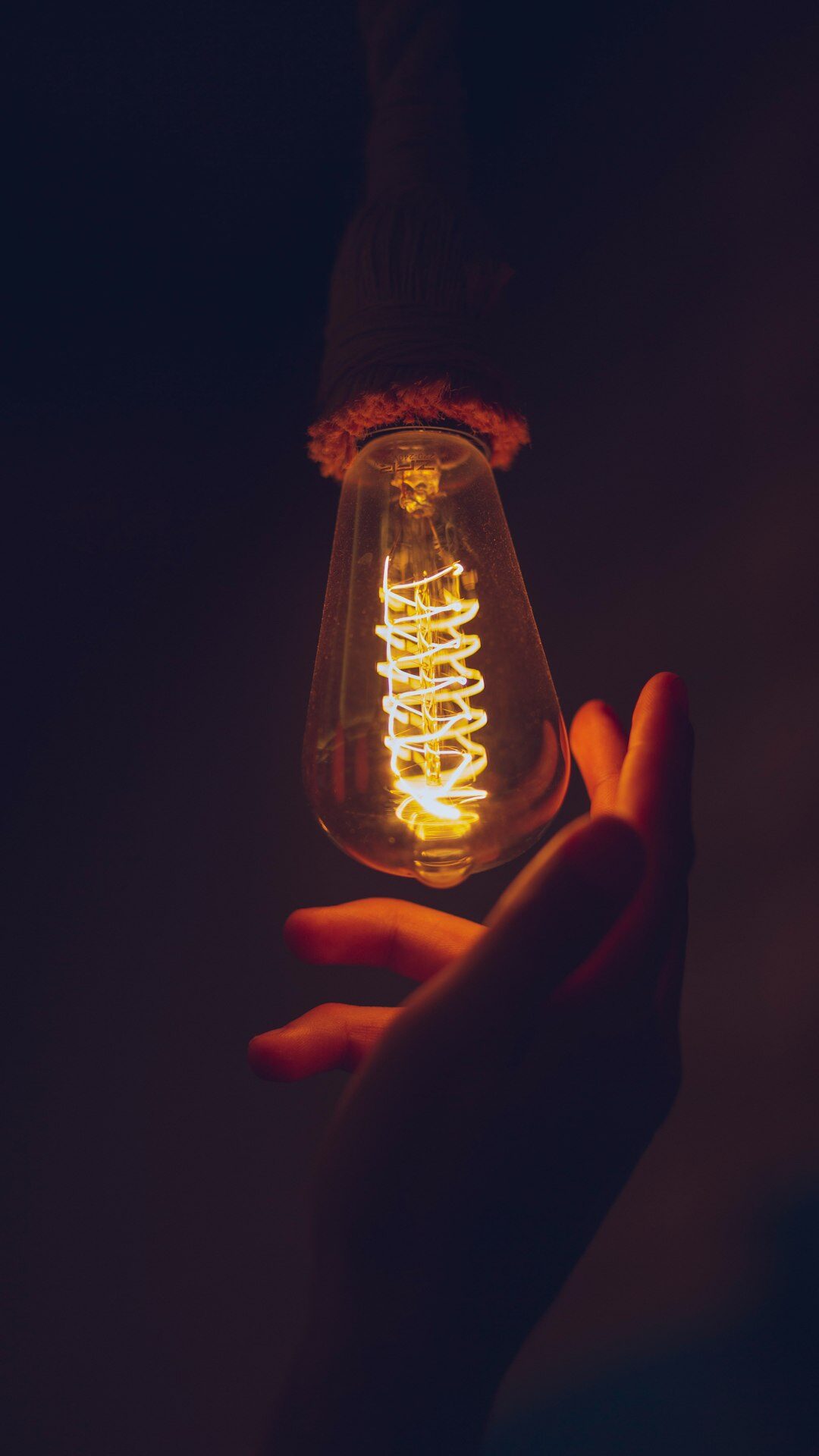 Hand holding a glowing lightbulb representing an idea