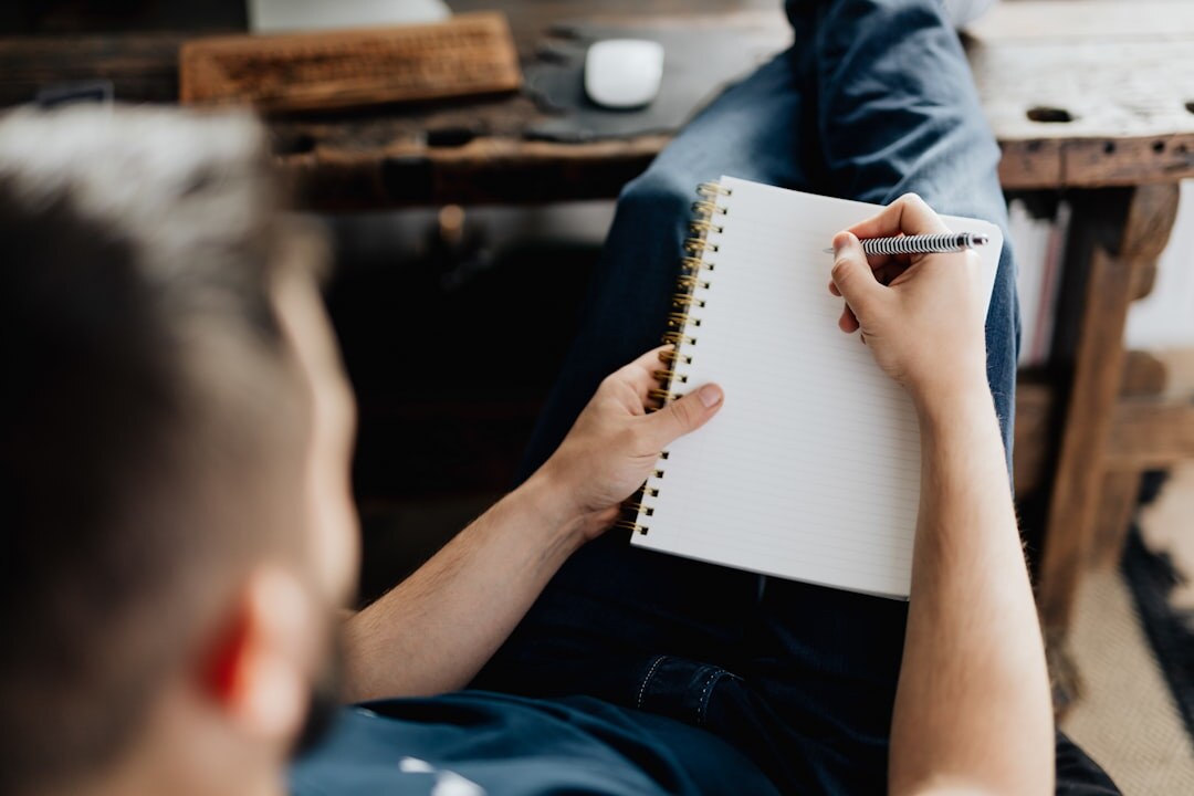 Person writing notes during a professional discussion